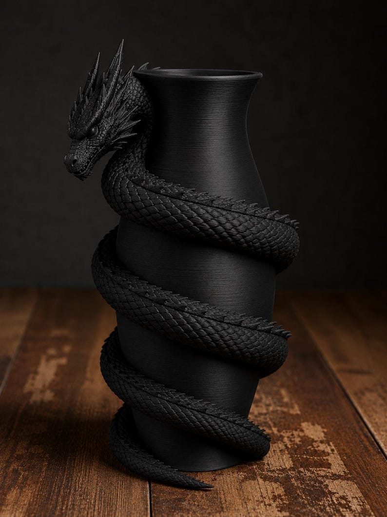May include: A black vase with a dragon wrapped around it. The dragon's head is at the top, and its body coils around the vase. The vase has a textured surface and sits on a wooden surface.