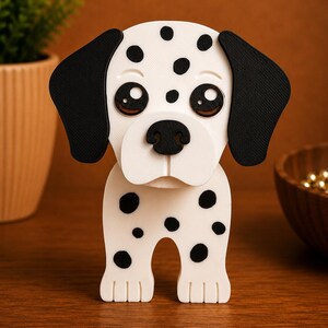 K&ouml;nnte beinhalten: Eine wei&szlig;-schwarz gefleckte Dalmatiner-Hundefigur. Der Hund hat gro&szlig;e, ausdrucksstarke Augen, schwarze Ohren und eine schwarze Nase. Die Figur steht auf einer Holzoberfl&auml;che.