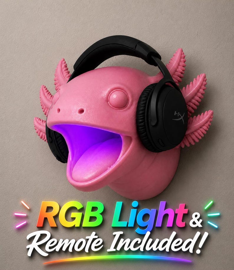 May include: A pink axolotl head sculpture with black headphones. The axolotl has feathery gills and an open mouth with a purple glow. The text "RGB Light & Remote Included!" is displayed in colorful letters.
