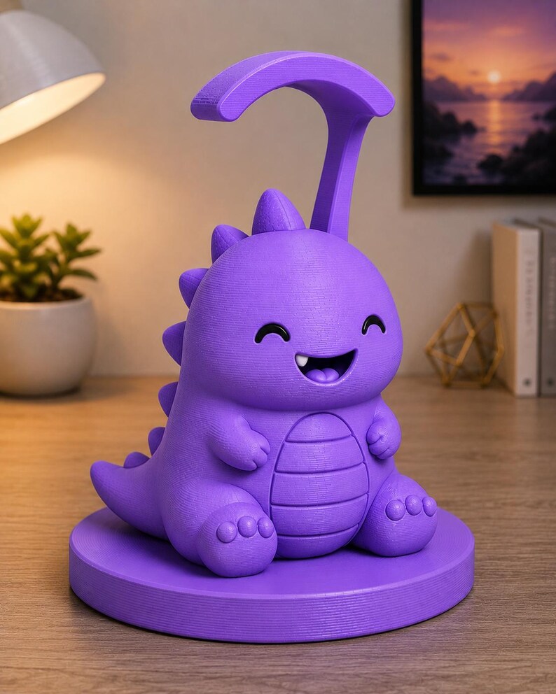 May include: A purple dinosaur-shaped desk lamp with a curved top and a smiling face. The lamp has a round base and a textured surface. The lamp is sitting on a wooden surface.