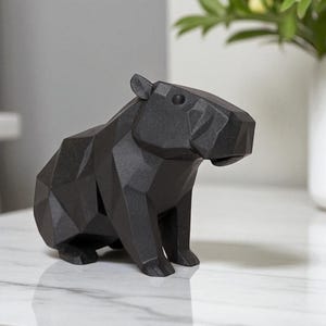 May include: A black geometric capybara sculpture. The sculpture is made of a series of angular planes, giving it a modern, abstract look. The capybara is sitting upright, with its head slightly turned.