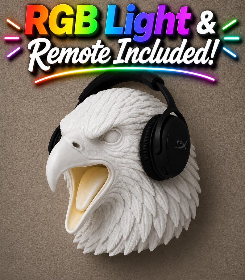May include: A white eagle head sculpture with a black headset. The eagle's beak is open, revealing a light yellow interior. The text "RGB Light & Remote Included!" is displayed above the sculpture in colorful letters.