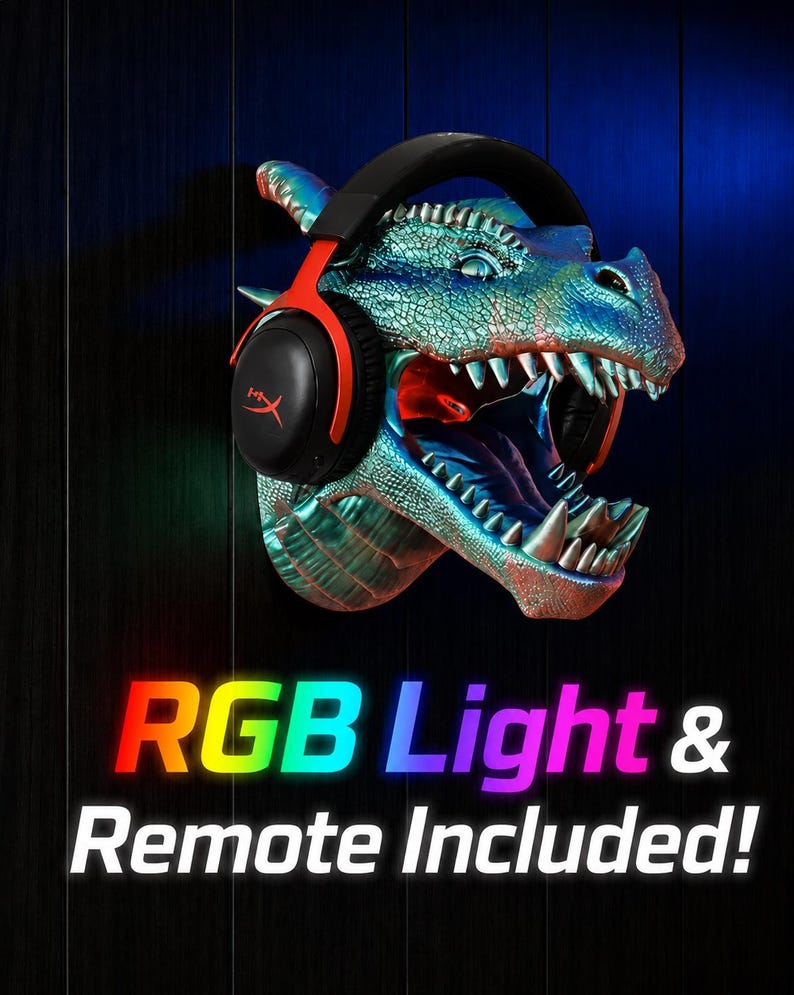 May include: A dragon head wall mount with a headset. The dragon is painted in shades of blue and green with red accents inside the mouth. The headset is black and red. The text "RGB Light & Remote Included!" is displayed in rainbow colors.