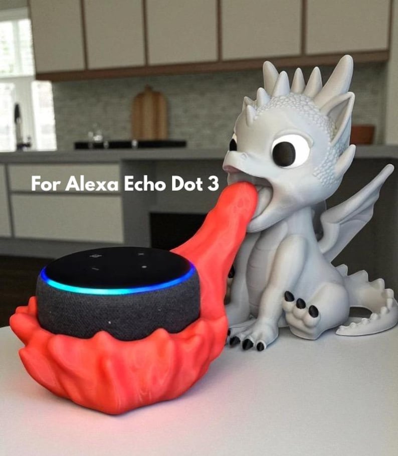 May include: A white dragon-shaped speaker holder with a red accent holding a black Alexa Echo Dot 3. The dragon has large eyes and a detailed design. The text "For Alexa Echo Dot 3" is visible.