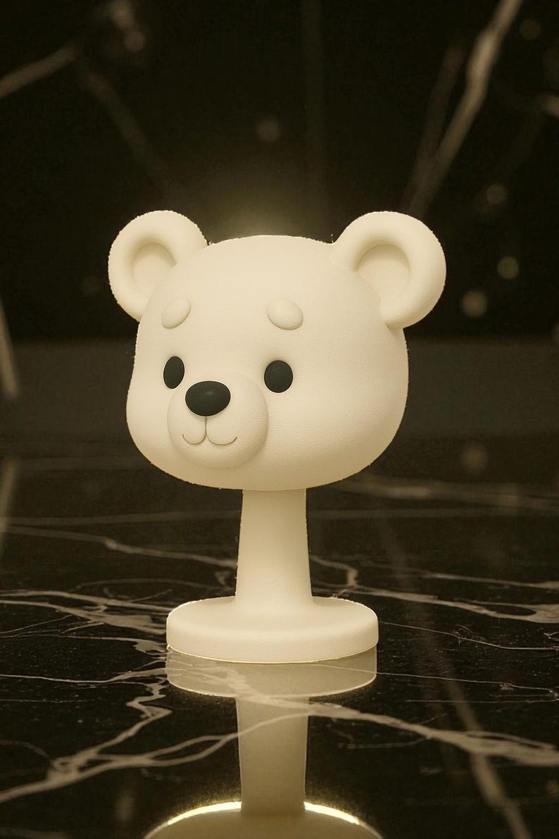 May include: A white bear-shaped decorative object with a round base and a slender stem. The bear has black eyes and a black nose, with a smiling mouth. The object is likely a lamp or a decorative piece.
