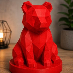Puede incluir: Una vibrante escultura de oso geom&eacute;trico rojo. El oso est&aacute; sentado erguido sobre una base circular. La superficie de la escultura est&aacute; compuesta por numerosos planos planos, creando una apariencia facetada. El oso es una pieza decorativa s&oacute;lida y llamativa.