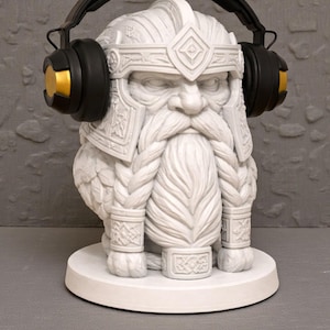 May include: A white statue of a bearded dwarf wearing a helmet and headphones. The headphones are black with gold accents. The statue is on a white circular base, set against a textured grey background.