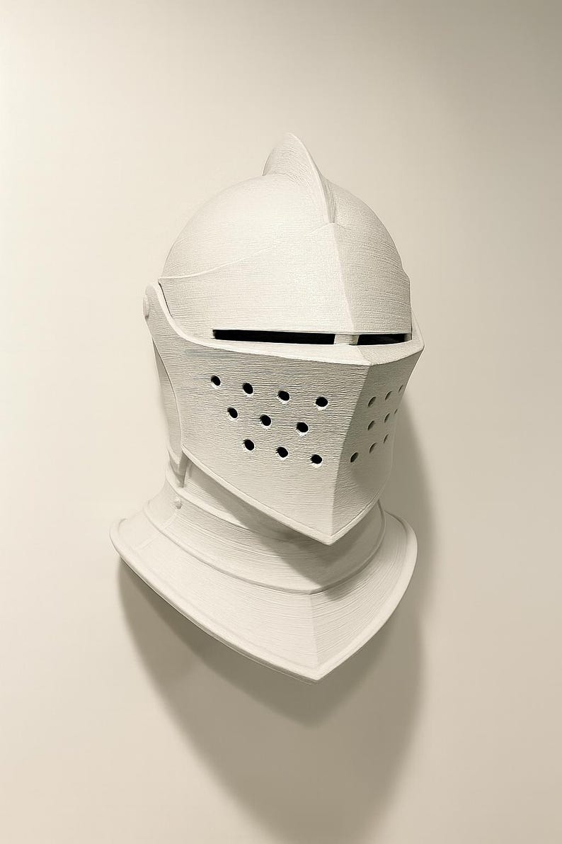 May include: A white knight's helmet with a visor and neck guard. The helmet has a textured surface and a series of small holes on the visor. The helmet is a decorative item, possibly for display or cosplay.