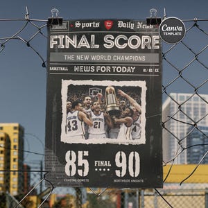 May include: A black and white sports poster with the headline "FINAL SCORE" and the text "THE NEW WORLD CHAMPIONS." The poster features a photo of a basketball team celebrating with a trophy. The final score is 85-90. The poster is held by binder clips.