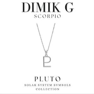 Puede incluir: Un collar de plata con un colgante en forma de la letra "P" con pequeñas piedras transparentes. El colgante está en una cadena de plata. El collar forma parte de la "Colección de Símbolos del Sistema Solar" y se llama "Plutón".