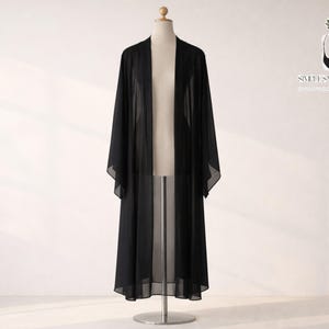 May include: A long, black kimono-style robe made of sheer fabric. The robe is displayed on a mannequin against a white background. The sleeves are wide and the robe falls to the ankles. The brand name "SWEET SWAY STYLES" is visible in the upper right corner.
