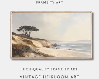 Op de afbeelding: Een ingelijst landschapsschilderij van een kustscène. Het kunstwerk toont een zandstrand, oceaangolven en een boom op een klif. Het schilderij heeft een vintage esthetiek met zachte kleuren en de tekst "FRAME TV ART", "HIGH-QUALITY FRAME TV ART" en "VINTAGE HEIRLOOM ART".