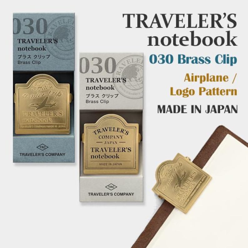 May include: Gold-colored brass clip for a Traveler's notebook. The clip features an airplane design and the text "Have a nice trip". The packaging includes the text "Made in Japan".