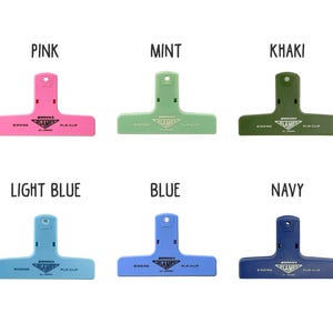 Puede incluir: Seis clips de encuadernaci&oacute;n de pl&aacute;stico en varios colores: rosa, verde menta, caqui, azul claro, azul y marino. Cada clip tiene el texto "Penco Clamp" impreso.