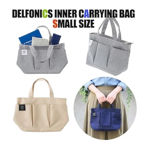 Könnte beinhalten: DELFONICS INNER CARRYING BAG SMALL SIZE Tragetaschen in verschiedenen Farben. Die Taschen sind in grau-weiß gestreiftem Stoff, Beige und Marineblau abgebildet. Jede Tasche hat mehrere Außentaschen und einen Griff. Eine Tasche wird von einer Person gehalten.