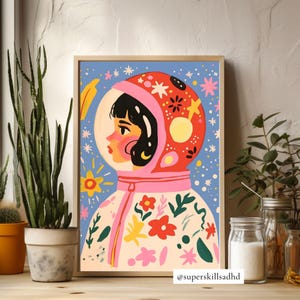 May include: A colorful illustration of a person wearing a pink and red astronaut helmet with a white spacesuit decorated with flowers and stars. The background is a blue sky with white stars. The text "@superskillsaddhd" is at the bottom of the image.