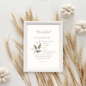 Puede incluir: Impresión enmarcada con las palabras "Afine Einfach" en la parte superior. La impresión tiene un marco blanco y presenta texto y un diseño de hojas de acuarela. Espigas de trigo y calabazas decorativas rodean la impresión.