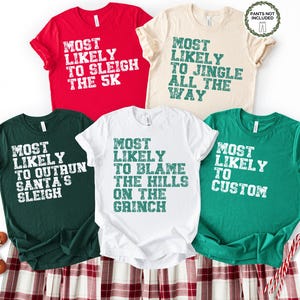 May include: A collection of five short-sleeved t-shirts in red, cream, green, white, and dark green. Each shirt features a different holiday-themed phrase in a distressed font, such as "Most Likely to Sleigh the 5K" and "Most Likely to Jingle All the Way."