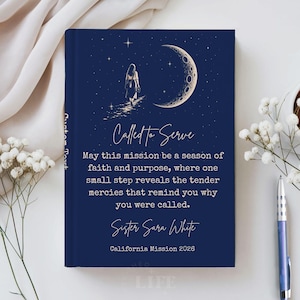 May include: A dark blue hardcover book featuring a gold illustration of a person walking toward a crescent moon and stars. The text reads: Called to Serve, May this mission be a season of faith and purpose, Sister Sara White, California Mission 2026.