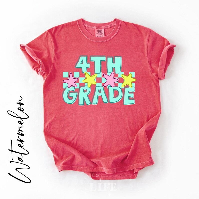May include: A red t-shirt with the words "4th Grade" in turquoise and white, with pink and yellow stars. The word "Watermelon" is written in cursive on the left side of the shirt.