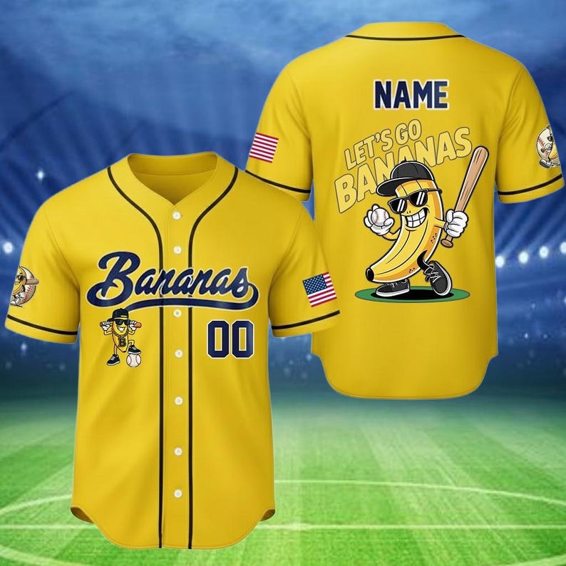 Puede incluir: Camiseta de b&eacute;isbol amarilla con ribete negro. La parte delantera muestra la palabra "Bananas" en escritura azul marino. La camiseta tiene un personaje de pl&aacute;tano de dibujos animados y el n&uacute;mero "00". La parte trasera tiene el texto "Let's Go Bananas" y un personaje de pl&aacute;tano con un bate de b&eacute;isbol.