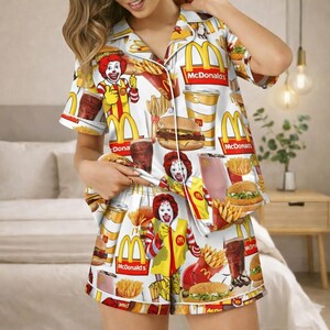 Puede incluir: Un juego de tres tazas de cer&aacute;mica con un esmalte moteado de color crema. Cada taza presenta un dise&ntilde;o pintado a mano diferente: una hoja azul y verde, una flor amarilla y una baya roja. Las tazas tienen una forma simple y redondeada.