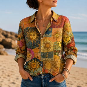 May include: A long-sleeved button-down shirt featuring a vibrant, multi-colored collage print of various sun illustrations and celestial motifs. The shirt includes a central rectangular graphic labeled THE SUN, a classic collar, and a buttoned front.