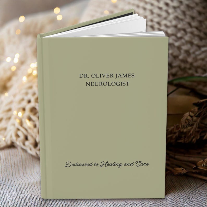 K&ouml;nnte beinhalten: Ein gr&uuml;nes Buch mit dem Text "DR. OLIVER JAMES NEUROLOGIST" und "Dedicated to Healing and Care" auf dem Einband.