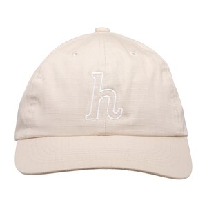 Peut inclure: Casquette de baseball beige avec une visière incurvée. La casquette présente un "h" minuscule blanc brodé sur le devant. Fabriquée en tissu texturé, elle est ornée d'un bouton sur le dessus.