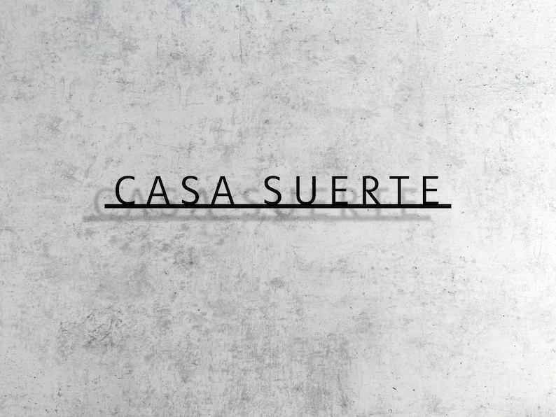 May include: A white wall with the words "CASA SUERTE" written in black lettering.