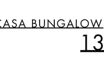 May include: A graphic design featuring the black text CASA BUNGALOW in a clean, sans-serif font, with the number 13 positioned below and to the right. The text is presented on a plain white background, maintaining a clear and legible layout.