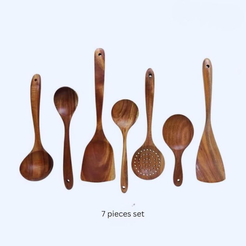 May include: A collection of seven wooden kitchen utensils, including a ladle, spoons, and spatulas. The utensils are made of light brown wood and have a smooth finish. The text "7 pieces set" is at the bottom.