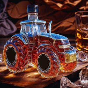 Puede incluir: Una botella decorativa de vidrio con forma de tractor y tapón negro. La botella está llena de un líquido marrón rojizo, y el diseño del tractor presenta detalles en rojo, azul y plateado. Se encuentra sobre una superficie de madera.
