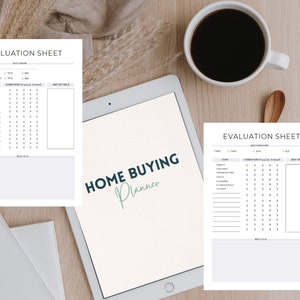 Puede incluir: Un planificador de compra de vivienda con hojas de evaluaci&oacute;n, una tableta y una taza de caf&eacute;. El planificador incluye secciones para evaluaciones de cocina y ba&ntilde;o. La tableta muestra el texto "Home Buying Planner".