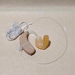 Clear clip Single invisible retention clip hearing aid and cochlear implant