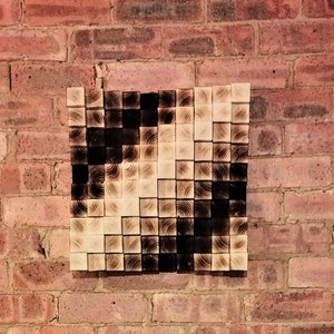 May include: A brick wall with a wooden wall art piece above a black electric fireplace with a realistic flame effect.
