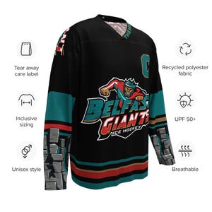 May include: Black hockey jersey with teal and red stripes. The jersey features a large graphic of a cartoon character with a crown and the text "Belfast Giants Ice Hockey".
