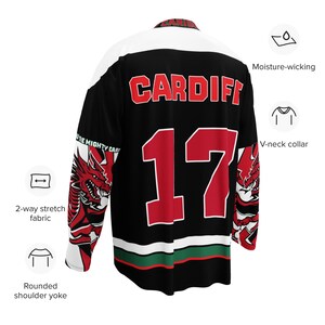 May include: Black and red hockey jersey with a white stripe across the chest and a green and white stripe at the bottom. The jersey has a red dragon on the sleeve and the text "CARDIFF" and the number "17" on the back.