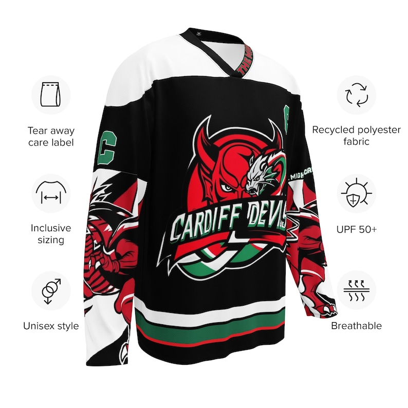 May include: Black and white hockey jersey with a red, green, and white logo that says "Cardiff Devils". The logo features a red devil with horns and a green dragon. The jersey has a white collar and white stripes around the sleeves and bottom.