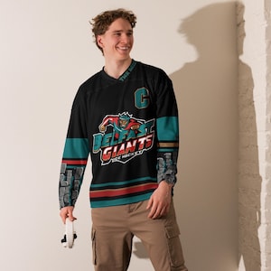 May include: Black hockey jersey with teal and gold accents. The jersey features a logo with a cartoon character and the text "Belfast Giants Ice Hockey".