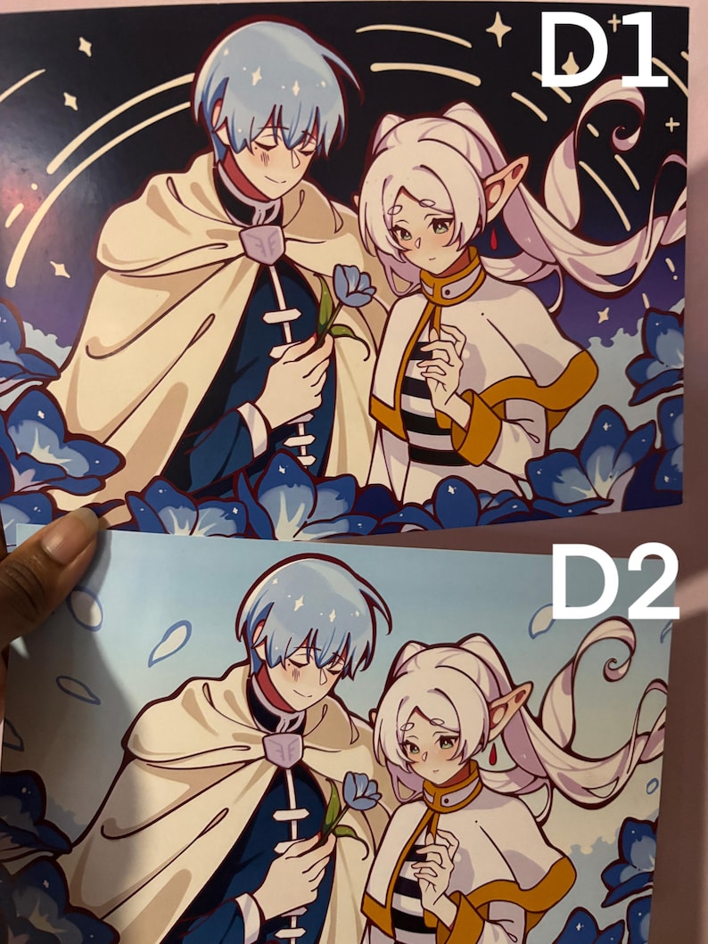 May include: Two anime-style prints, labelled D1 and D2, depicting a couple. The male figure has light blue hair and a cream-coloured cape. The female figure has white hair and a striped collar. Both are surrounded by blue floral elements.