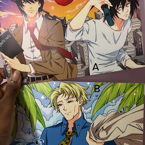 May include: Anime art prints featuring three male characters. One print shows a man in a brown suit holding a book with "DEATH NOTE" on it. Another shows a man on the phone. The third man is wearing a blue shirt and a patterned tie.