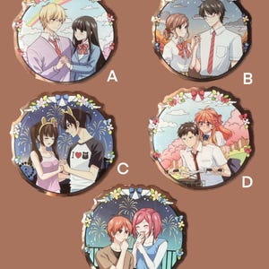 Peut inclure: Ensemble de cinq épingles rondes de style anime. Chaque épingle présente un couple dans un cadre romantique, entouré d'éléments floraux et décoratifs. Les épingles ont une bordure dorée et sont posées sur un fond marron.