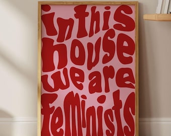 May include: A framed print with a pink background and red text that reads "In this house we are feminists".
