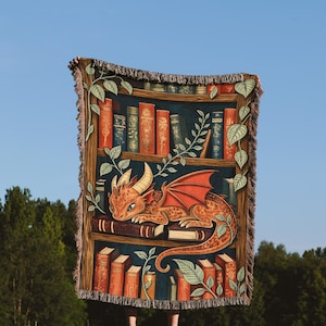 以下が含まれることがあります： 織り込まれたタペストリーの毛布は、本でいっぱいの本棚に巻き付いた赤いドラゴンを描いています。本棚は緑のつるで囲まれています。