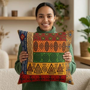 May include: A decorative pillow with a vibrant, geometric pattern in red, orange, green, and yellow. The design features tribal-inspired shapes, including triangles, circles, and lines, creating a bold and colorful accent piece for home decor.