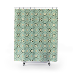 May include: A shower curtain featuring a repeating geometric pattern of teal, gold, and cream-colored shapes. The design consists of interconnected circles and curved lines arranged in a grid, suspended from a series of silver metal rings.