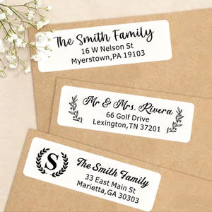 May include: Three white rectangular address labels with black text. The top label reads "The Smith Family" and includes an address. The middle label reads "Mr & Mrs. Rivera" and includes an address. The bottom label reads "The Smith Family" and includes an address.