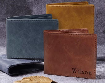 May include: Three leather wallets in different colors: blue, brown, and yellow. The brown wallet has the name "Wilson" embossed on it.