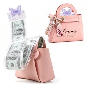 May include: A light pink handbag gift box featuring a butterfly topper and a decorative ribbon. One box is closed, displaying the name Emma, Happy 18th Birthday, and 07.30.2026. The other box is open, revealing a clear plastic strip holding US 100 dollar bills.